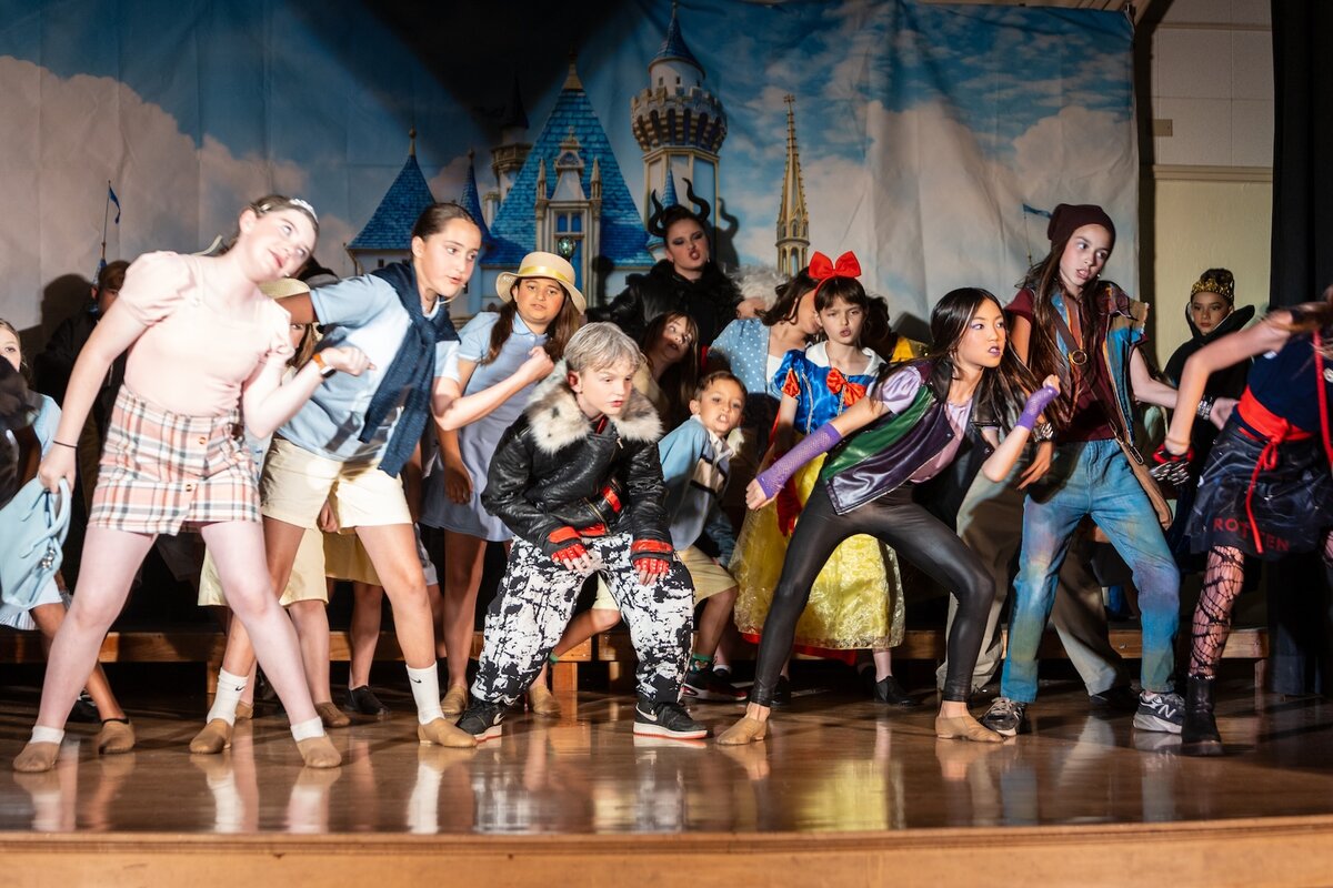 Four student cast members in character during a scene from Descendants
